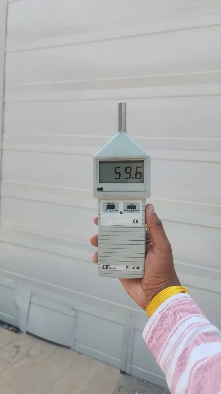 Sound-level meter displaying 59.6 beside side acoustic panels